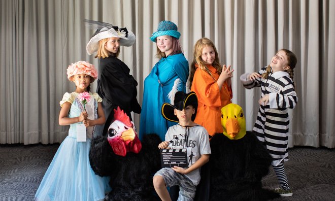Group of youth in costumes backstage.