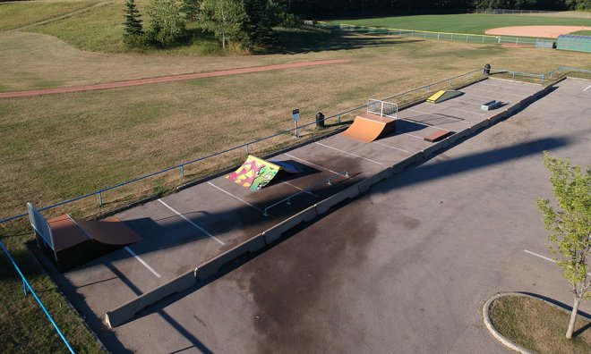 skateboard spot featuring two large ramps with a rail, and three smaller objects meant for grinding on a skateboard