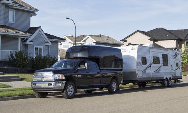 Recreational vehicle attached to a truck parked on the street