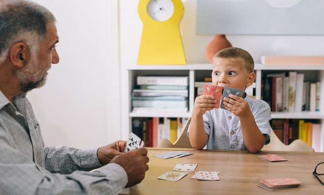 A grandfather and grandson playing cards