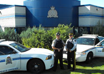 Image of two RCMP officers standing by vehicles
