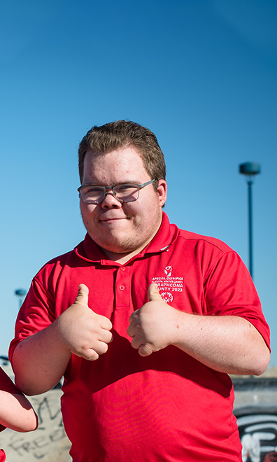 Declan poses with both thumbs up with a clear blue sky in the background.