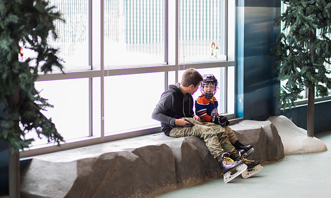 2 boys sitting in the leisure ice with skates