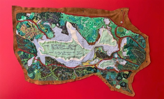 An artwork depicting a lush aerial view of the Cooking Lake area before colonization. The artwork is made of many colours of fabrics, ribbons, and beadwork sewn onto an elk-hide.