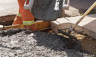 Construction worker smoothing out freshly poured concrete