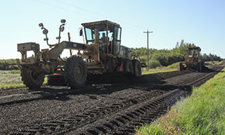 Graders reshaping gravel road