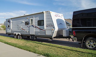 Image of an RV parked on the road attached to a truck