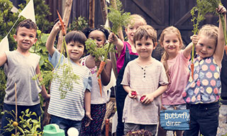 Group of children standing by a garden box.